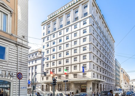 A multi-story hotel with a classic architectural style, featuring a prominent entrance and several balconies.