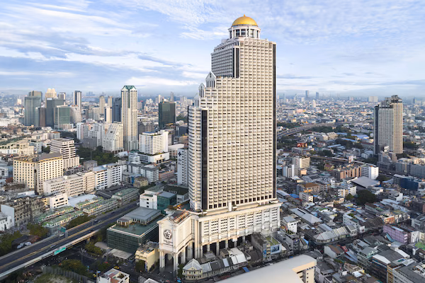 A high-rise building with a distinctive dome and a large, ornate entrance.