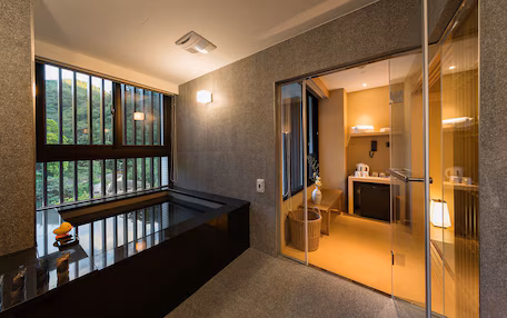A modern bathroom with a glass shower enclosure, a sink, and a toilet.