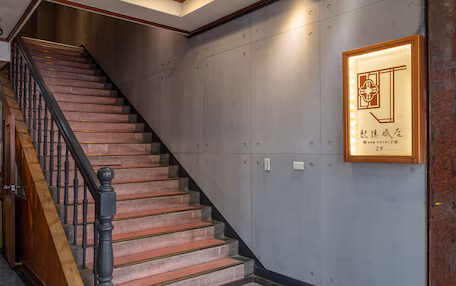 A staircase with wooden handrails and a wall-mounted sign.