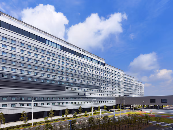 A modern hotel building with multiple floors, large windows, and a flat roof.