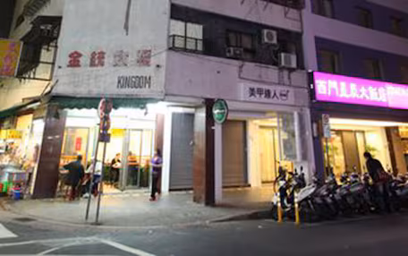 A hotel with a prominent sign, multiple floors, and a visible entrance.